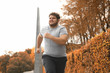 © New Africa - Young overweight man running in park. Fitness lifestyle