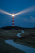 lighthouse of Ameland at night with light beaming across the deep blue sky