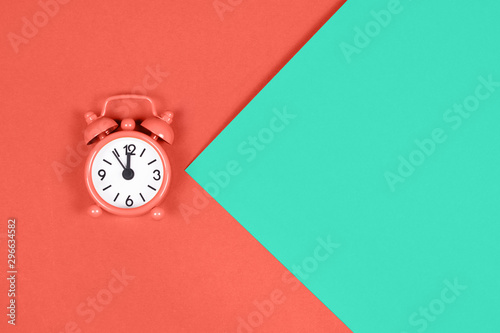 Fotografía Orange alarm clock on colored background.
