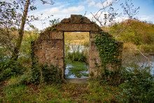 View Of A Peaceful Lake Seen Through The Doorway Of A Ruined Building