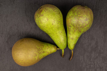 Group of three whole fresh green pear flatlay on grey stone