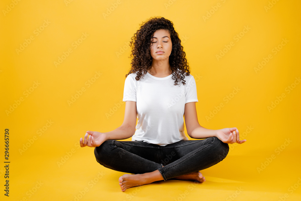 relaxed black woman meditating in yoga pose isolated over yellow - obrazy, fototapety, plakaty 