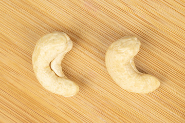 Group of two whole brown nut cashew flatlay on light wood