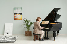Man Playing Grand Piano At Home
