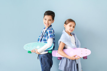 Wall Mural - Cute fashionable children with skateboards near color wall