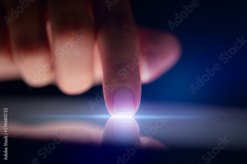 Cuadros en Lienzo Finger touching tablet with dark background with copyspace