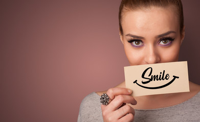 Person holding card with smile in front of her mouth