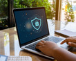 © RoBird - Person using a laptop computer with cyber protection and safe for global network security concept.