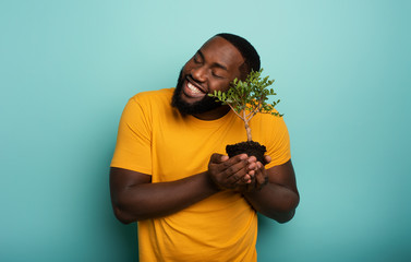 Wall Mural - Happy boy loves a small tree ready to be planted. Concept of forestation