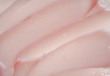 © Artem Mykhailichenko - Delicate pink texture and strokes of a cosmetic face mask or cream on a white background