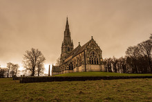 A Beautiful And Gothic Church Situated In A Park With Winter Trees All Around During A Dramatic And Moody Afternoon In Studley Park, UK.