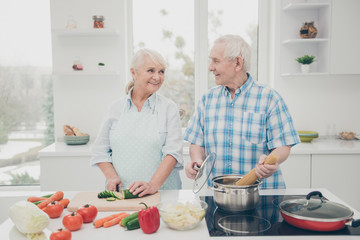 Portrait of his he her she nice attractive cheerful cheery careful people spouses cooking fresh delicious new domestic dishes in modern light white interior kitchen indoors