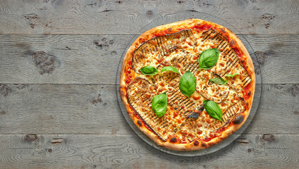 Wall Mural - Textured wooden Table with parmigiana pizza.