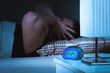 © terovesalainen - Noisy neighbors or loud party next door late in the middle of the night. Man holding and covering ears while trying to sleep. Tinnitus, otitis or bad soundproofing concept.