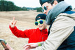 © iordani - young father with his son having fun outside in spring field, happy family smiling, lifestyle people making selfie wearing sunglasses