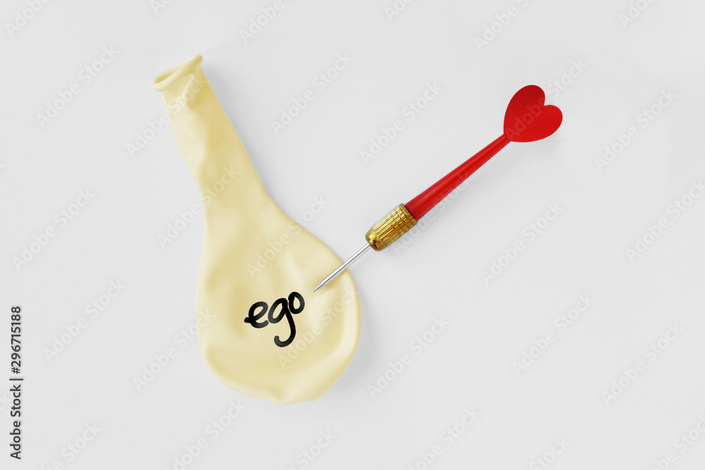 Deflated balloon with the word ego on it and arrow dart with heart on white background - Ego and love concept - obrazy, fototapety, plakaty 