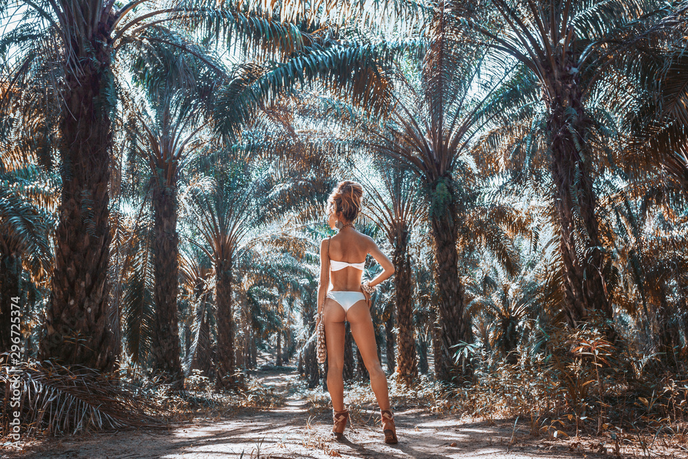 beautiful young woman in white bikini on tropical nature background - obrazy, fototapety, plakaty 