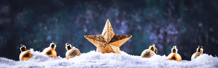 Wall Mural - Christmas background with golden star. New Year's decor. Christmas balls in smowdrifts and golden bokeh lights