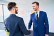 © baranq - Two businessmen shaking hands in office after successful deal