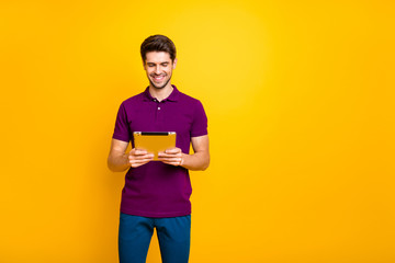 Portrait of his he nice attractive focused cheerful cheery guy using reading ebook isolated over bright vivid shine vibrant yellow color background