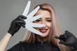Portrait of a cute smiling blonde girl manicurist holding nail clippers in one hand, and in the second a nail file for processing nails isolated on a gray background.