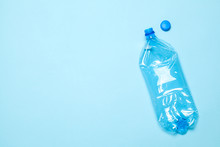 Crumpled Plastic Bottles On A Blue Background. Plastic Trash. Copy Space For Text.