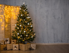 Christmas And New Year Evening Background - Christmas Tree, Heap Of Gifts, Folding Screen With Lights And Copy Space Over Concrete Wall