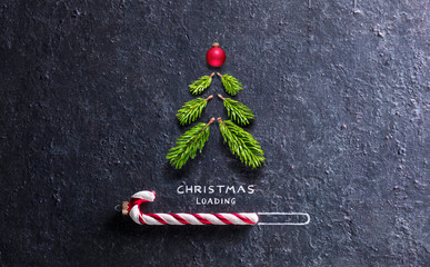 christmas card - loading concept - tree and candy canes on black stone