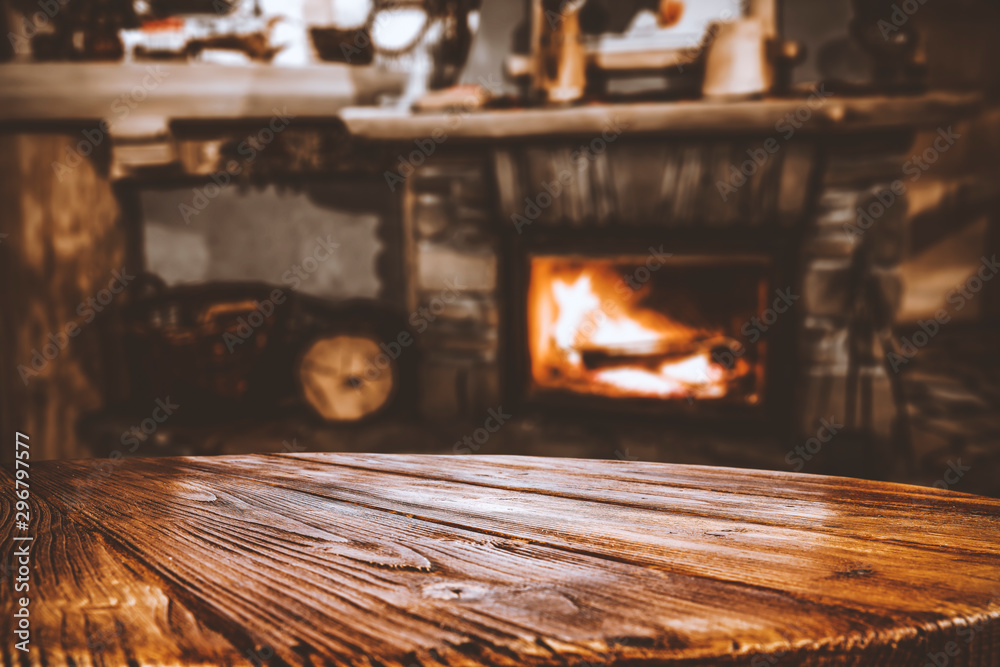 Wooden top with cosy warm home interior with fireplace background. - obrazy, fototapety, plakaty 