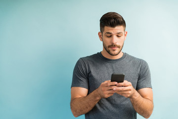 Good Looking Young Man Surfing On Smartphone