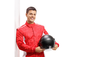 Poster - Car racer holding a helmet and leaning against a wall