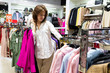 Woman with fuschia color blouse in her hands in clothing shop