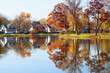 Beautiful autumn Midwest nature background.Fall view of private houses neighborhood with classic American middle class homes and colorful trees along a pond reflected in a water.Tenney Park,Madison,WI