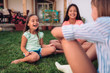 © kerkezz - Girls sitting on the grass and playing hand-clapping games