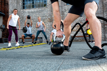 Group of people training, black kettlebell