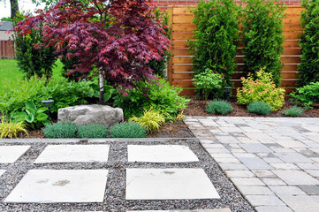 Detail of a beautiful, modern Asian inspired patio, walkway and horizontal cedar fence. in an urban backyard.