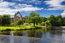 12th Century Augustinian Bolton Priory Church Ruins On The River Wharfe With Stepping Stones At Bolton Abbey England
