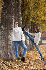 Young woman in a white woolen sweater and blue jeans