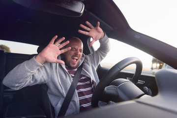 Young man driving a car shocked about to have traffic accident.