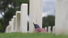 American Flag Waves Next To Grave In Military Cemetery, Slow Motion