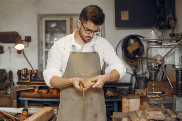 Wall Mural - Man working with a wood. Carpenter in a white shirt