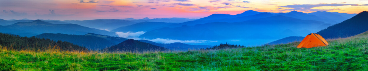 Wall Mural - orange tent on plain in the mountains