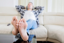 Blurred Background Of Young Man Relaxing On Sofa
