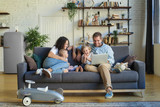 Fototapeta Młodzieżowe - Young beautiful happy family relaxing at home