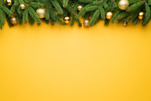 Christmas Yellow Background With Fir Tree Border And Decoration