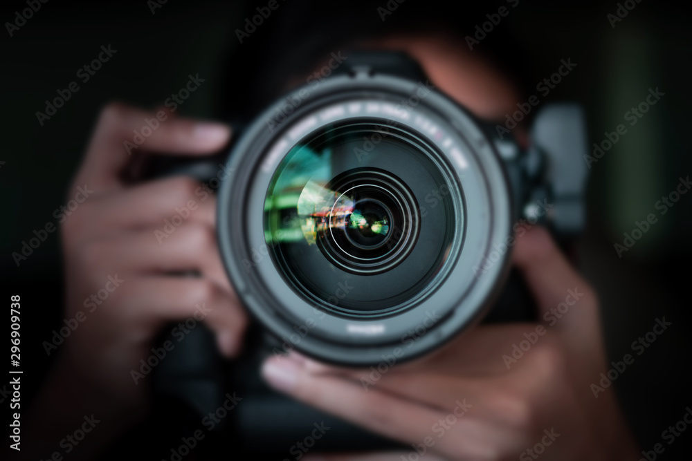 photographer  take pictures Snapshot with camera. man hand holding with camera looking through lens.Concept for photographing articles Professionally. - obrazy, fototapety, plakaty 