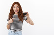 Surprised and impressed speechless cute redhead female student, pointing black credit card, staring amazed and astonished, explain cool banking offers, open deposit, have big cashback