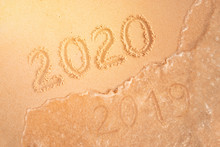 Number Of The New Year Written In Sand, On Tropical Beach. Change Numbers 2019 To 2020. New Year Holidays On A Tropical Island. The Sea Wave Washes Away The Inscription 2019.
