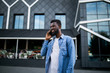 © F8  \ Suport Ukraine - Young black african man smiling and talking on mobile phone outside