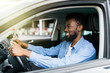 © F8  \ Suport Ukraine - Happy young african american man driving a car on street roads